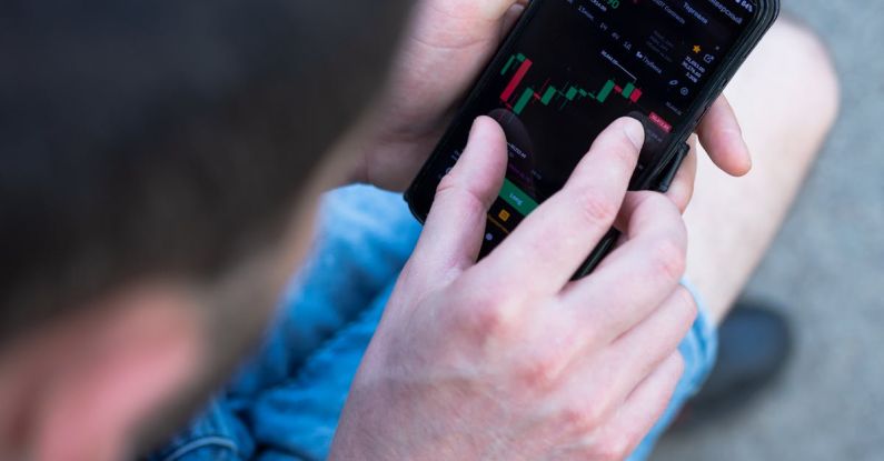Mobile Optimization - A man is using his cell phone to look at the stock market