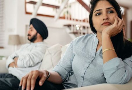 Avoiding Pitfalls - Sad young Indian woman avoiding talking to husband while sitting on sofa