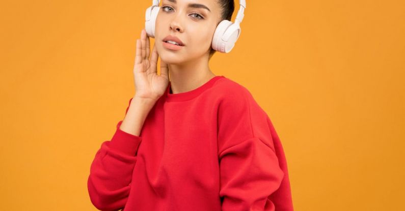 Trends Update - Woman in Red Sweatshirt and Blue Jeans Wearing White Headphones