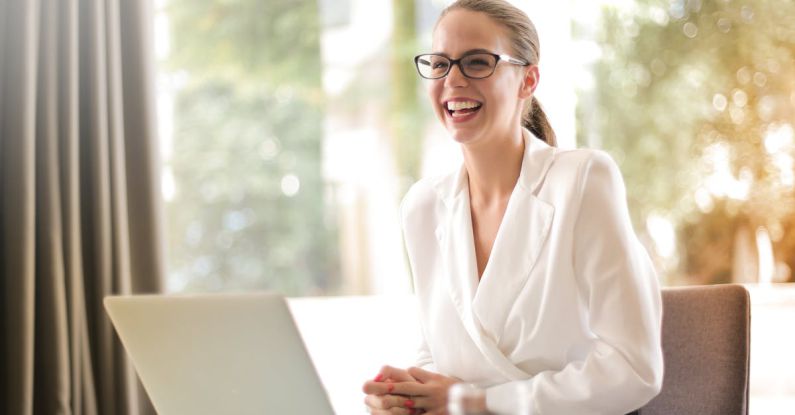 Analytics Content - Laughing businesswoman working in office with laptop