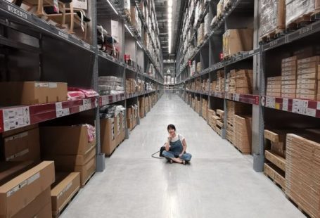 Inventory Management - Person Sitting on Ground Between Brown Cardboard Boxes