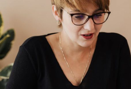 Content SEO - Content elegant adult female with short haircut in eyeglasses using laptop while working on business project in modern office